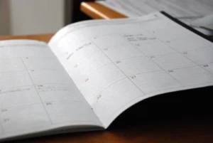 2026 Vision Board Ideas: 30 Themes, Layouts, and Aesthetics for the New Year Open monthly planner spread on a wooden desk, ready for new year goal setting