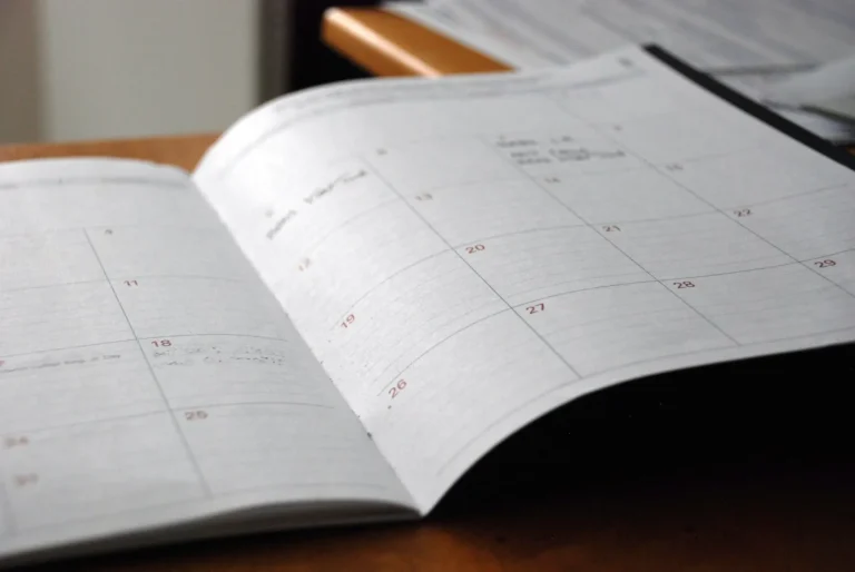 Open monthly planner spread on a wooden desk, ready for new year goal setting
