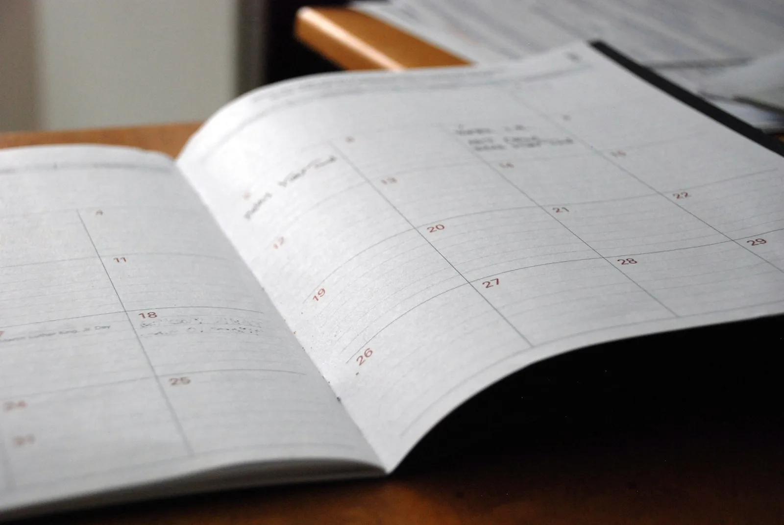Open monthly planner spread on a wooden desk, ready for new year goal setting