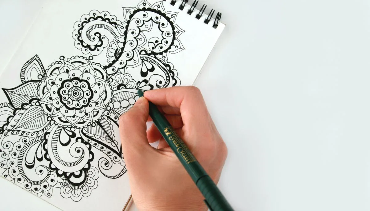 Hand drawing floral doodles in a journal