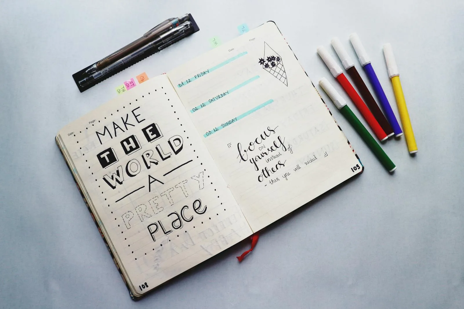 Open bullet journal with colored pencils for a mood tracker