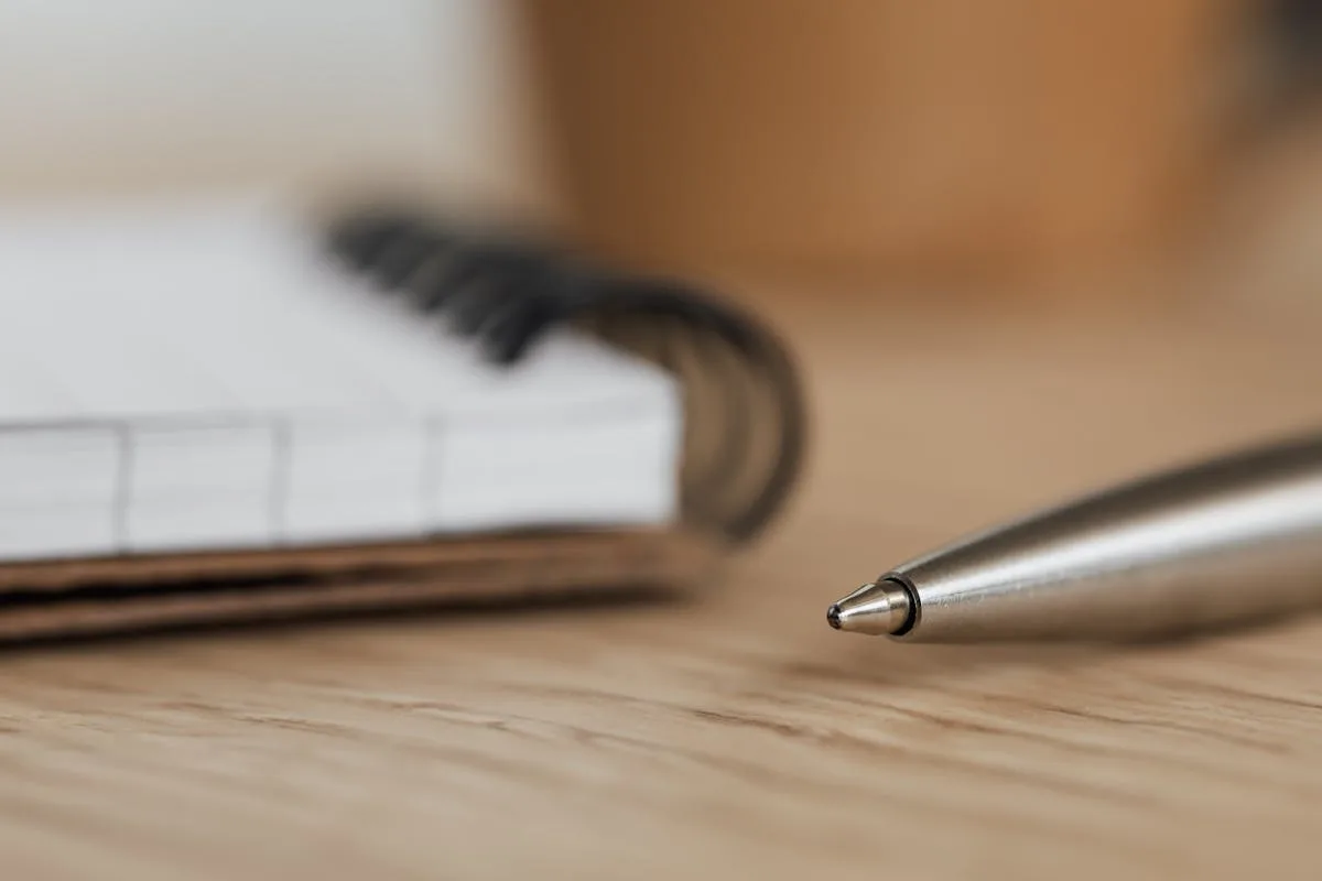 A fineliner pen resting on a dot grid notebook page