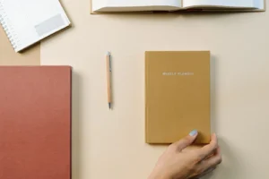 Best Bullet Journal Supplies: Notebooks, Pens, and What to Skip Several notebooks and planners with a pen on a warm neutral desk