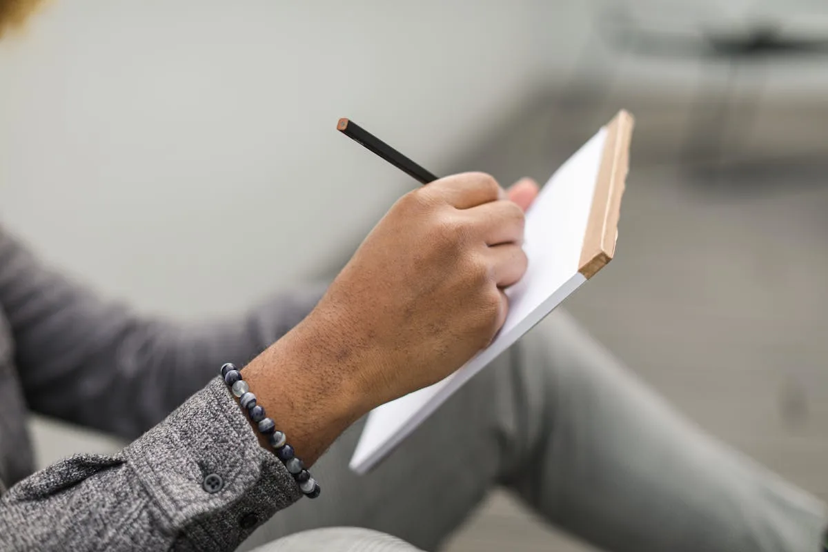 A hand writing rapid-log entries in a bullet journal