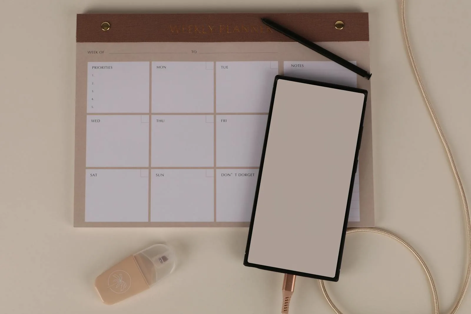 Warm-toned weekly planner pad with day-by-day checkboxes on a neutral desk