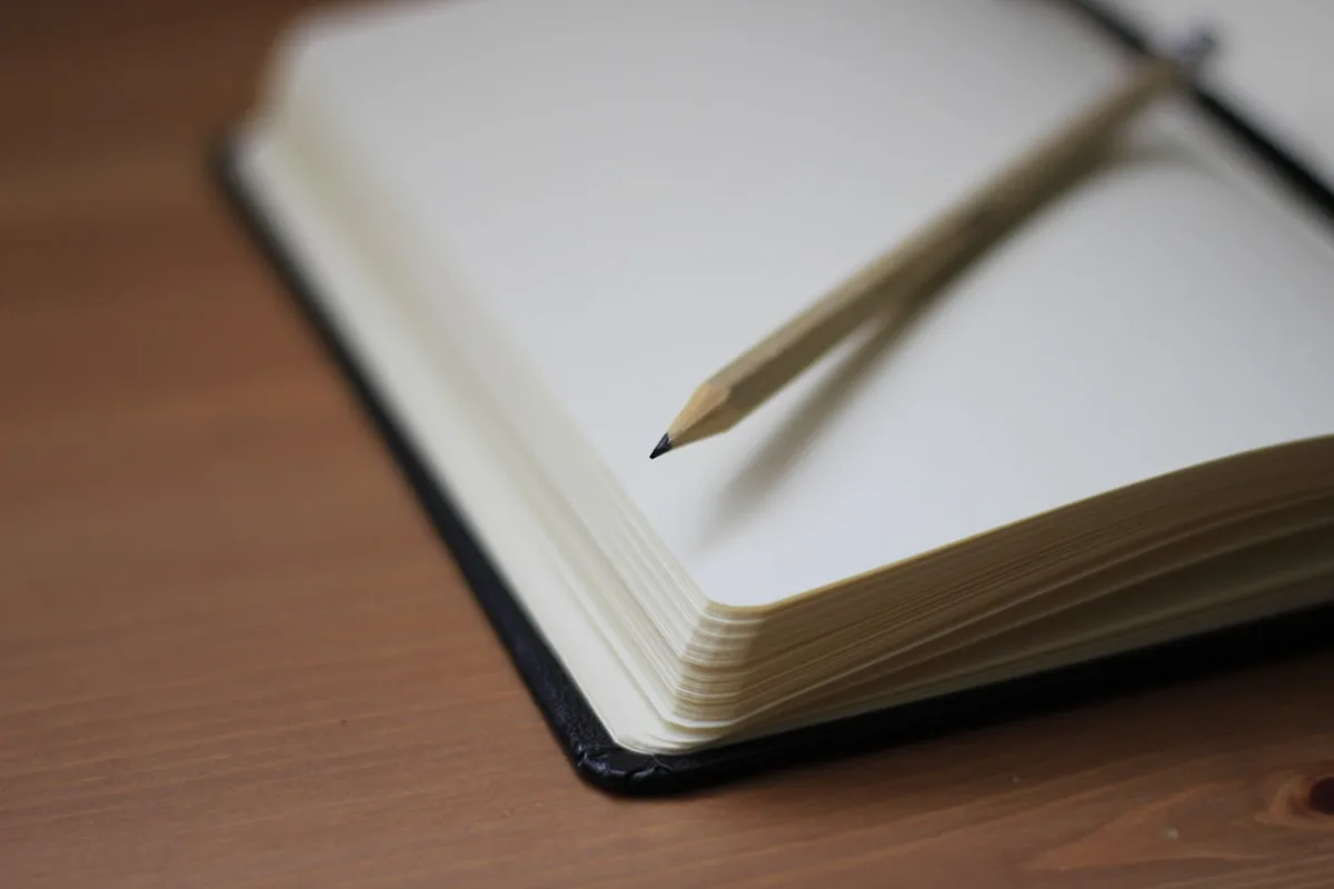 Open blank journal with a pencil resting on the page, ready for a workout log