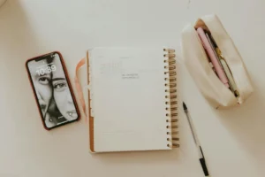 Free Homeschool Planner Printables: The Pages a Teaching Parent Actually Uses Open spiral planner showing a monthly calendar beside a pencil case on a warm neutral desk