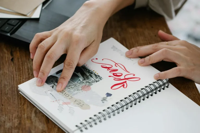 Woman making a junk journal scrapbook at a table