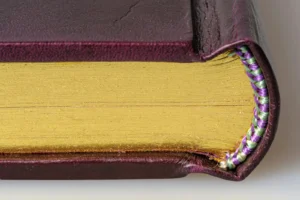 Close-up of a sewn book binding with colored thread visible along the spine of a handmade journal