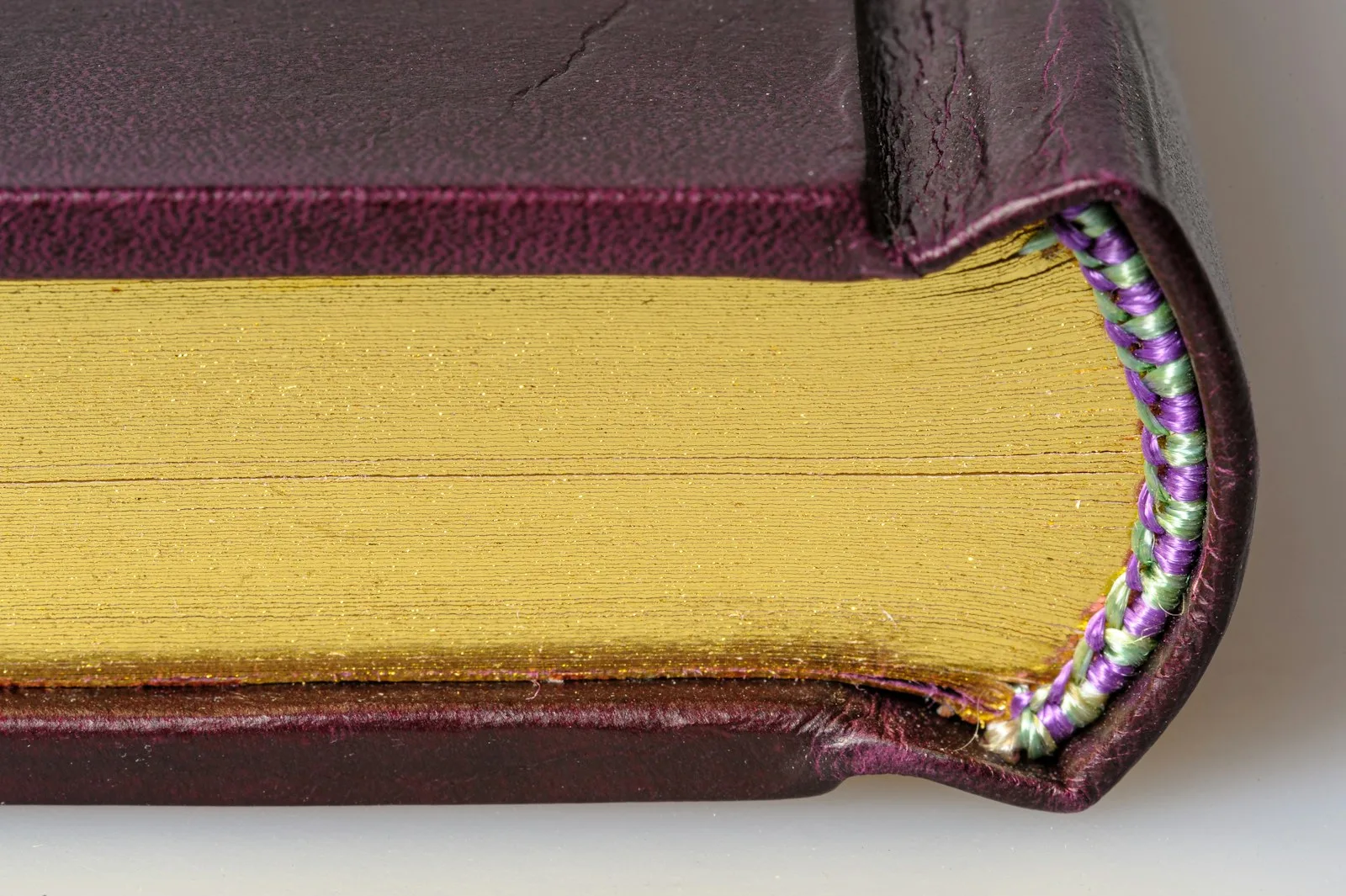 Close-up of a sewn book binding with colored thread visible along the spine of a handmade journal