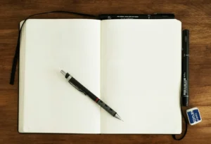 A blank dot grid notebook and a pen ready to start a new bullet journal