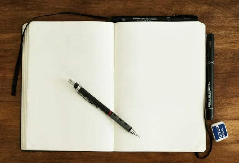 A blank dot grid notebook and a pen ready to start a new bullet journal