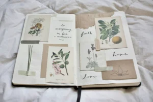 Open junk journal spread with botanical illustration cards and the handwritten words faith, hope, and love