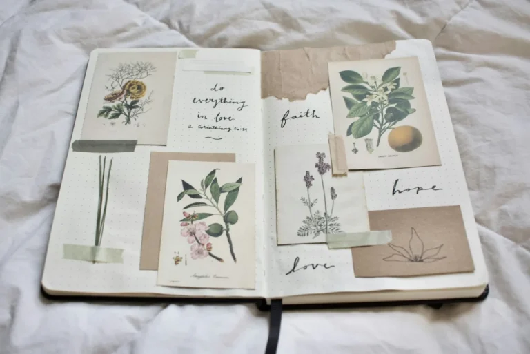 Open junk journal spread with botanical illustration cards and the handwritten words faith, hope, and love