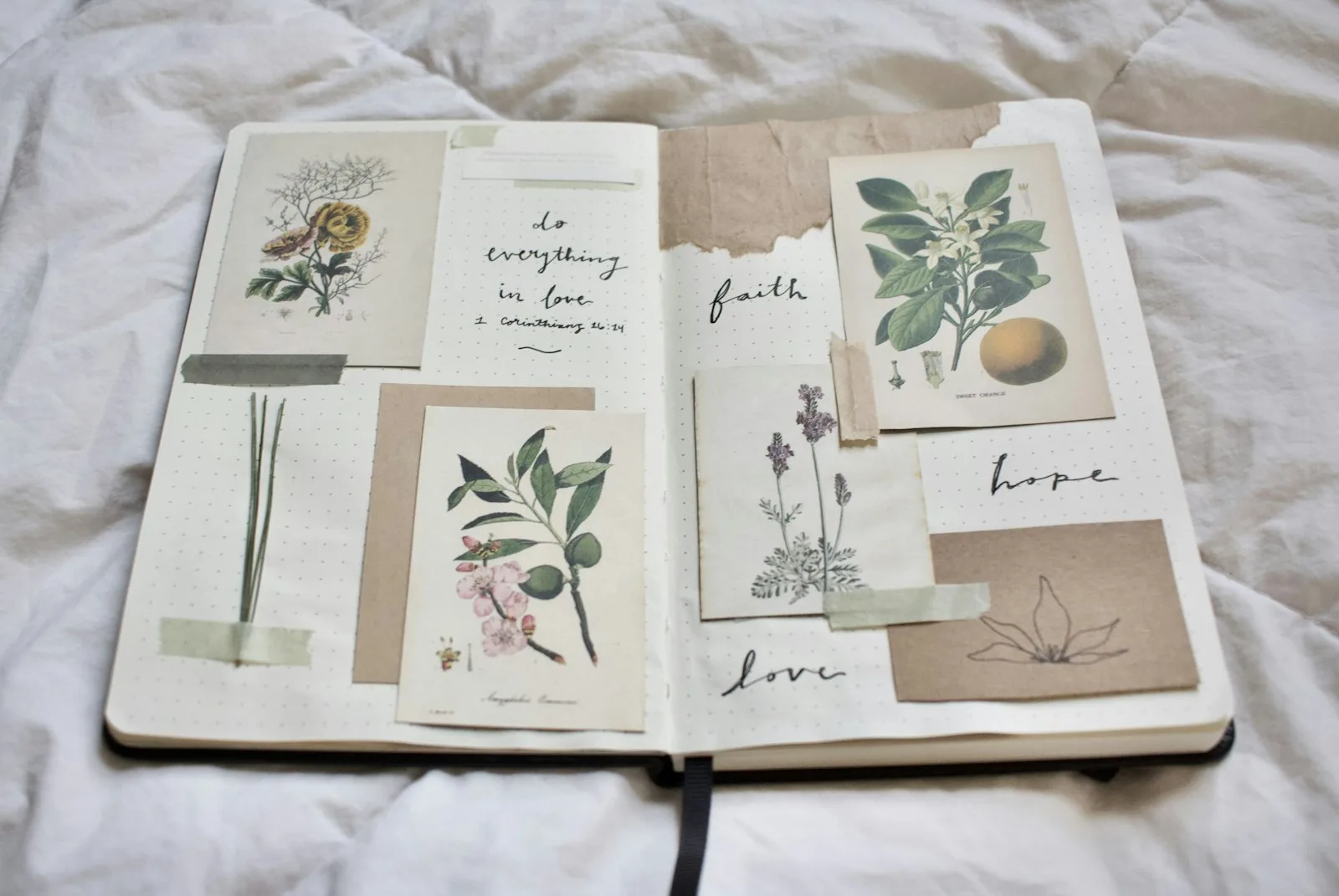 Open junk journal spread with botanical illustration cards and the handwritten words faith, hope, and love