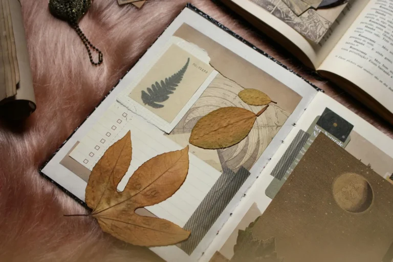 Open junk journal spread with pressed leaves, vintage stamps, and layered paper