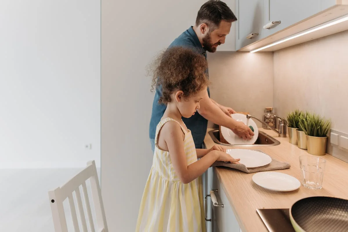 Two children helping with chores in the kitchen