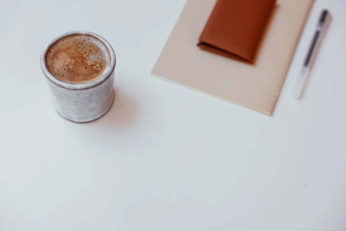 Plain notebook and coffee on a clean desk