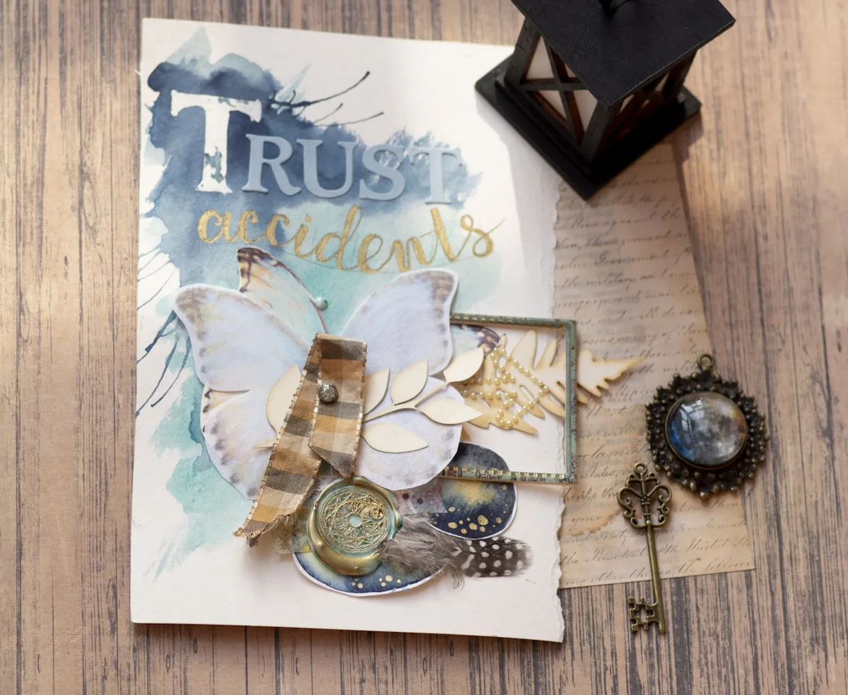 Mixed-media junk journal cover with a butterfly, wax seal, and vintage key