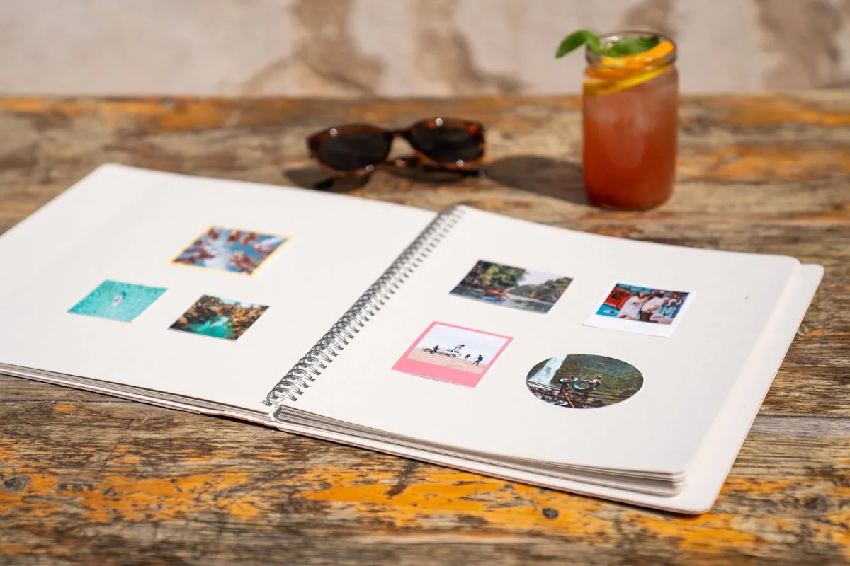 Open photo scrapbook album with instant photos on a wooden table