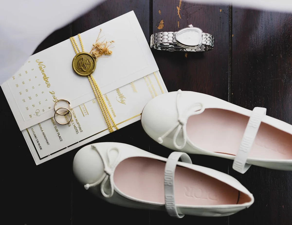 Wedding flat lay with an invitation, wax seal, rings and bridal shoes