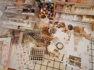 Vintage scrapbooking flat lay with patterned papers, scissors, and craft supplies on a desk