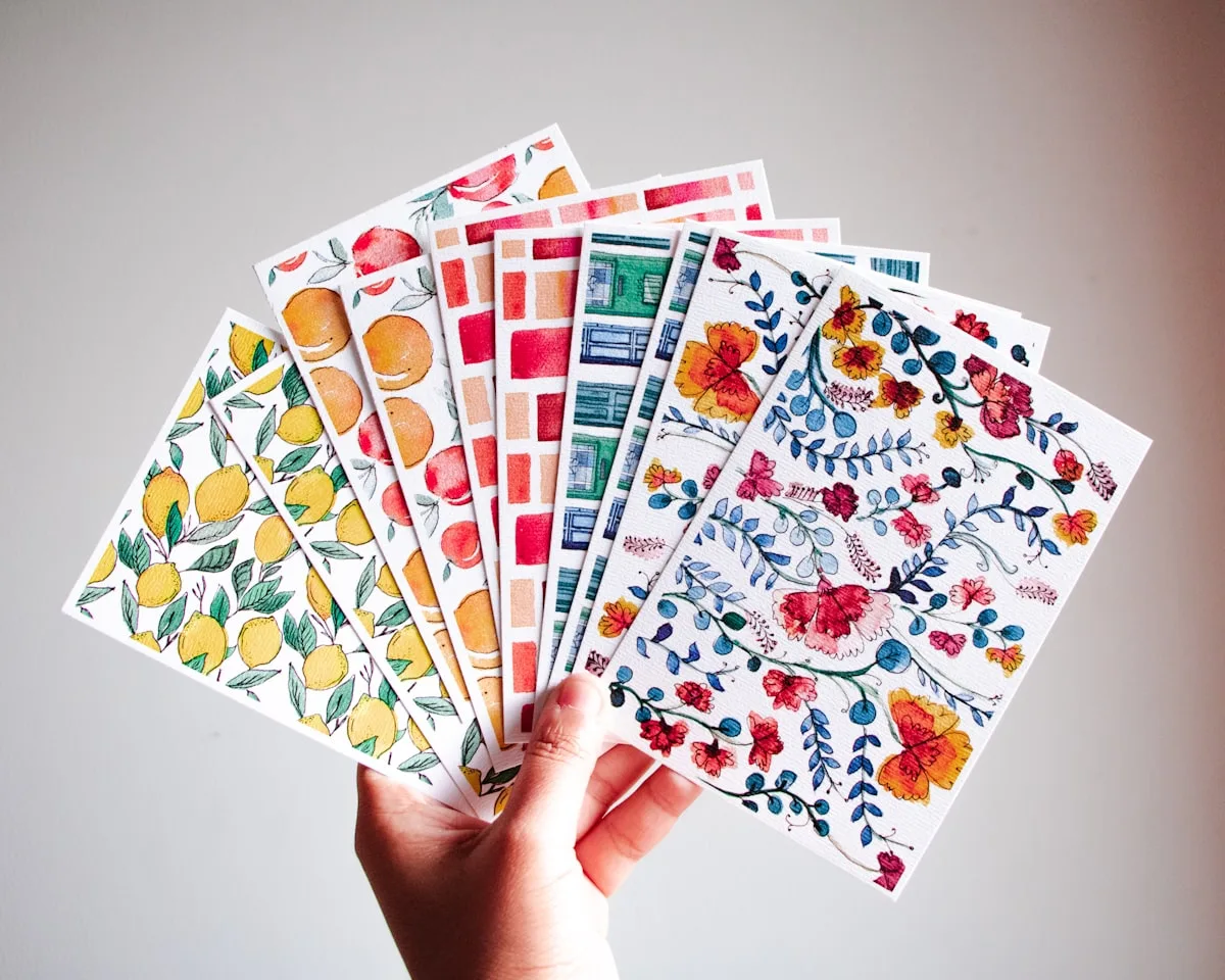Hands holding colorful printable sticker sheets