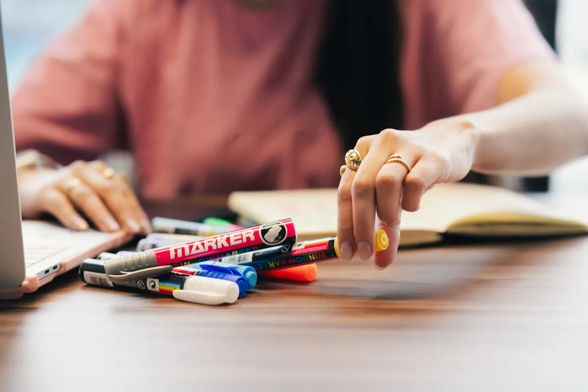 Magazines, markers, and craft supplies spread on a desk ready for a teen vision board session
