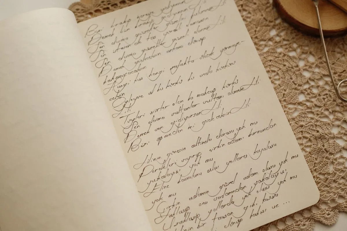 Cream journal page with handwritten cursive in brown ink, resting on a crochet lace doily