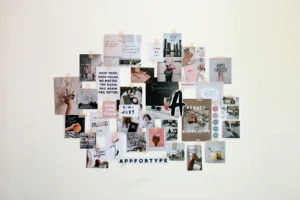 An aesthetic vision board mounted on a white wall with overlapping photo and quote cutouts arranged in an organic cluster