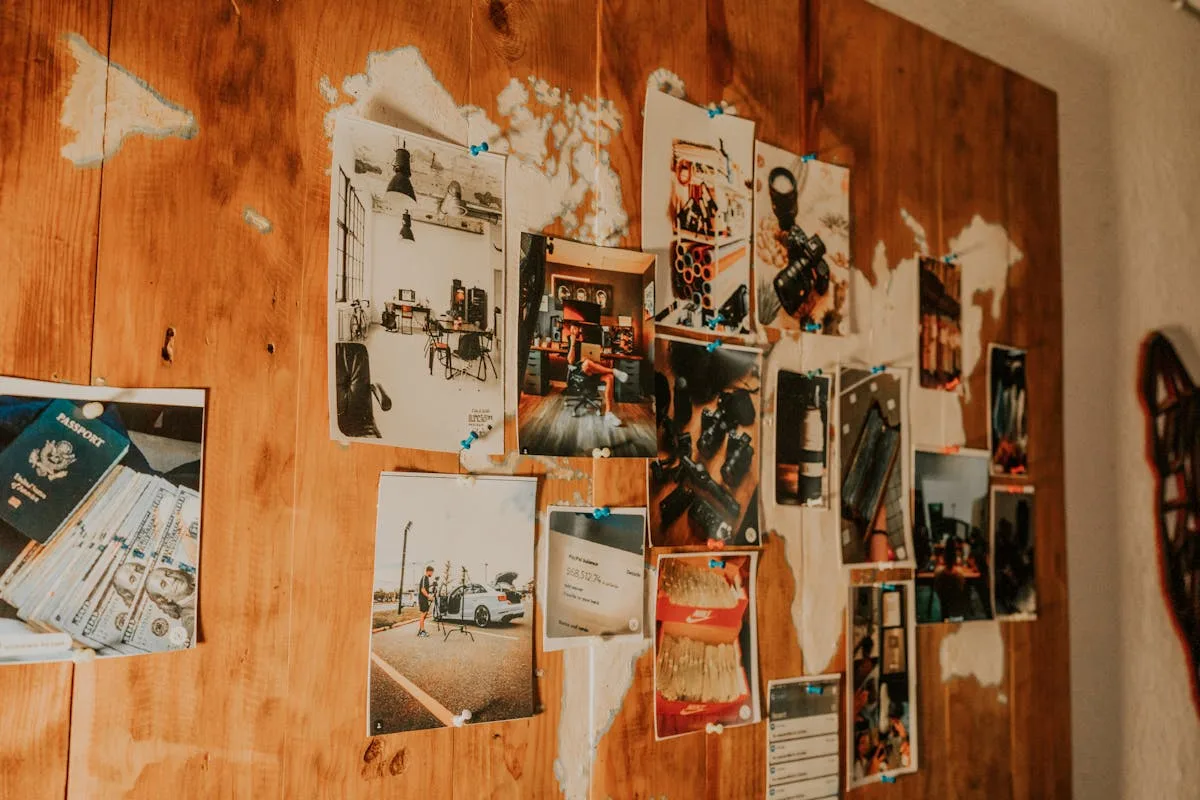 A wooden wall covered in pinned photos and printed cards arranged as a mood board