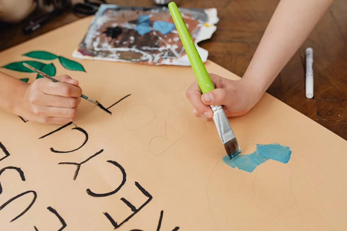 Affordable DIY vision board supplies on a wooden table: poster board, scissors, and paper