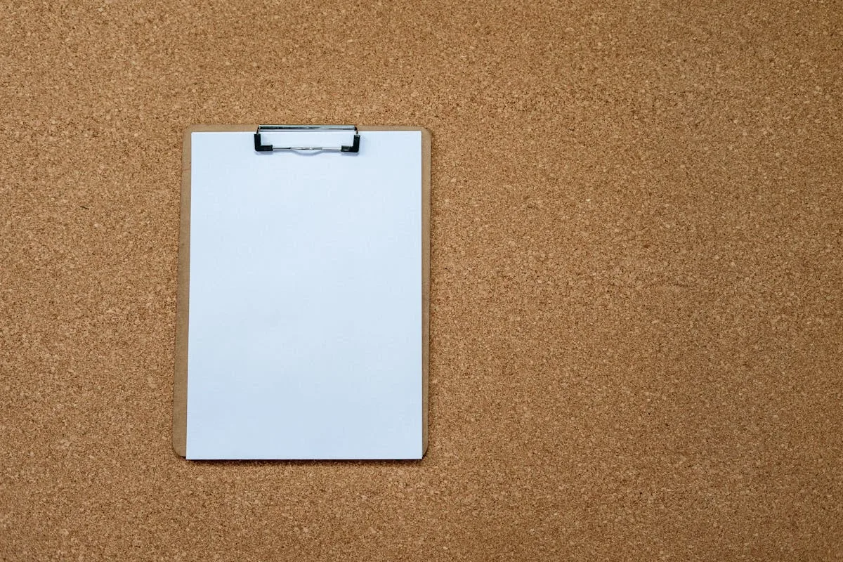 A blank cork board with a clipboard pinned to it, ready for a vision board