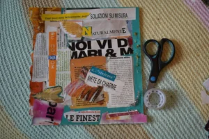 Vision board flat lay with magazine cutouts, scissors, and tape on a soft rug