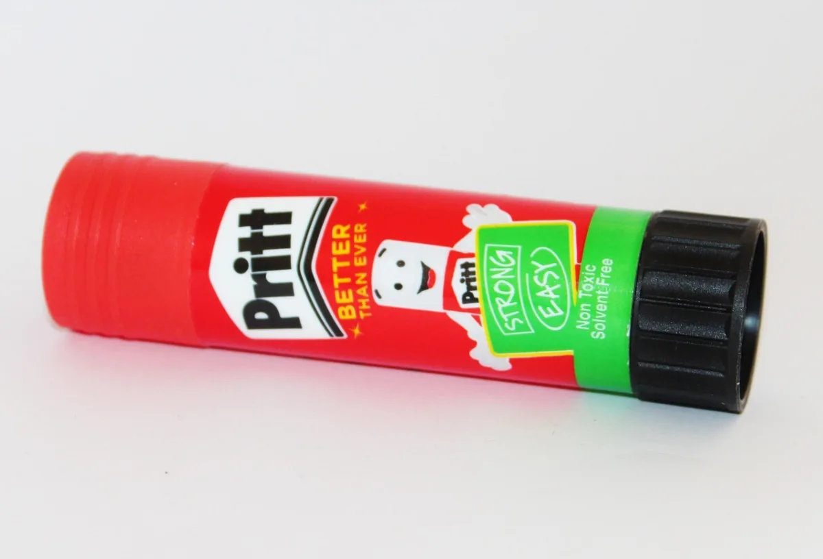 A close-up of a red glue stick used for paper crafts