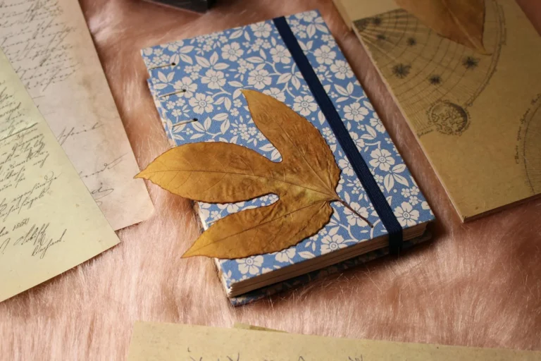 Handmade junk journal with a floral cover resting among vintage letters