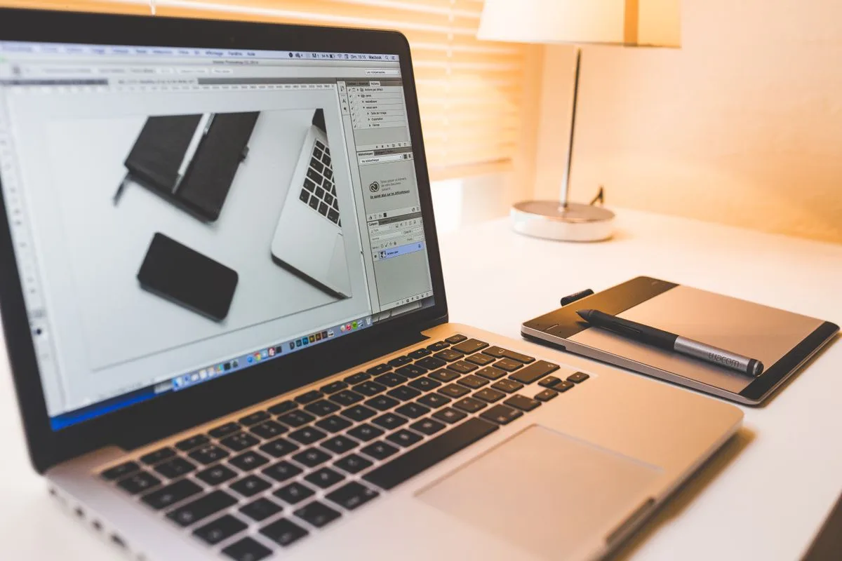 Designer working on a laptop at a warm wooden desk