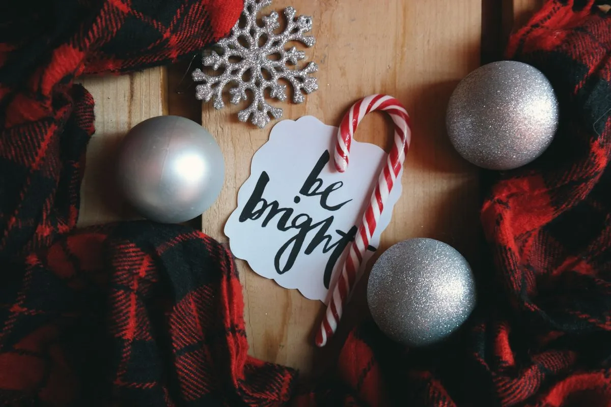 Cozy Christmas flat lay with a hand-lettered card and ornaments