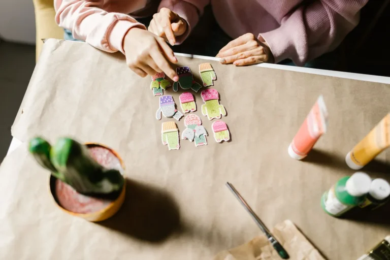 Hands assembling a scrapbook at a craft table