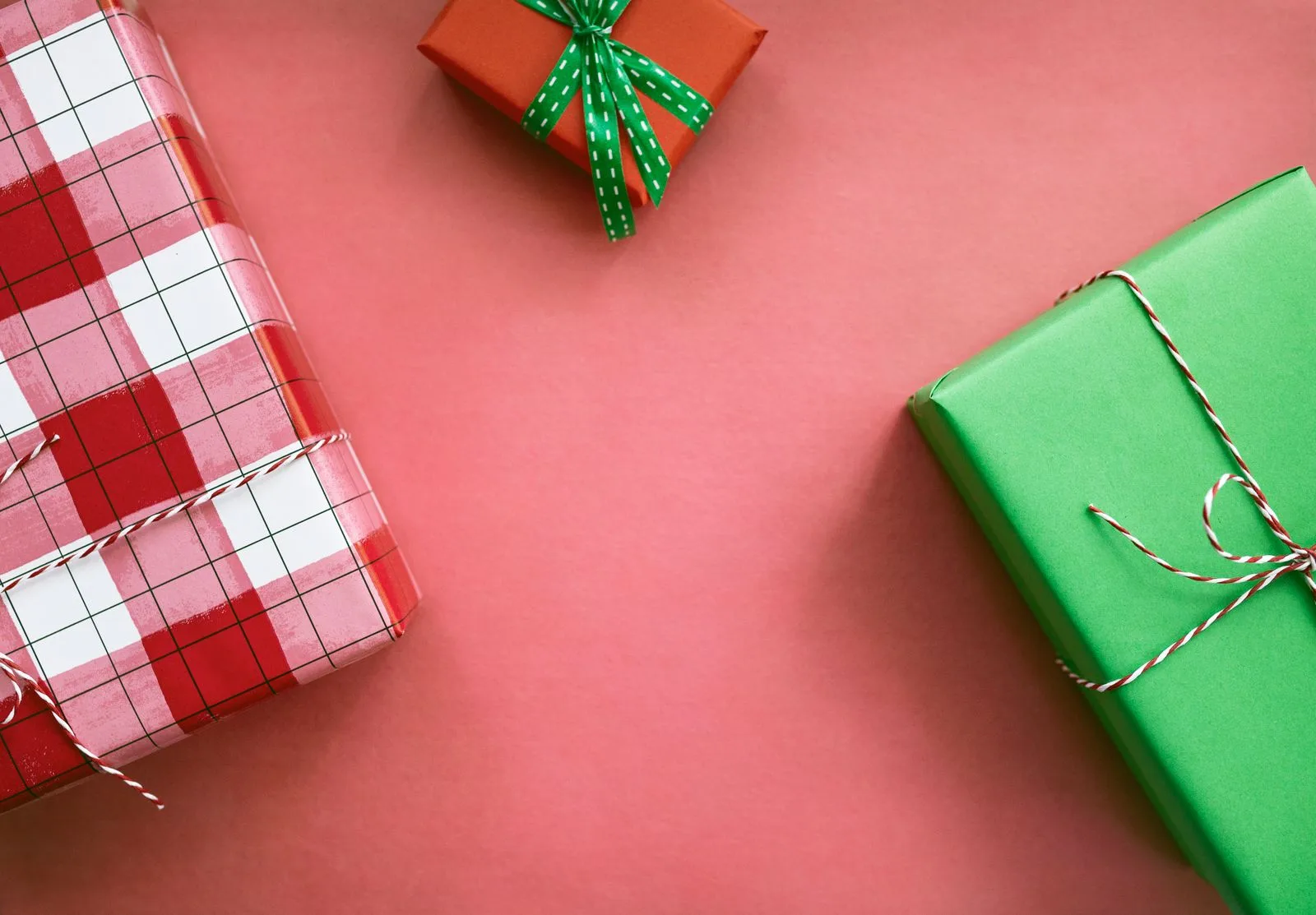 Christmas presents wrapped in red plaid and green paper tied with twine